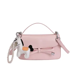 Elegante bolso de mano rosa para mujer con lazo y dije de perlas para uso casual diario.