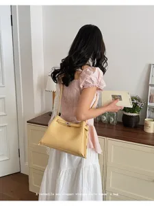 Chic yellow leather shoulder bag for women, elegant vintage style crossbody bag with metal lock.