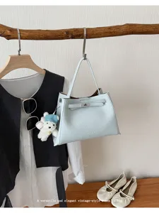 Elegant light blue leather handbag with shoulder strap and chic padlock design for women.