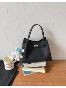 Vintage style minimalist black leather tote bag with metal lock detail for daily commute.