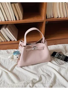 Pink leather top handle handbag with metal lock and elegant vintage style for daily wear.