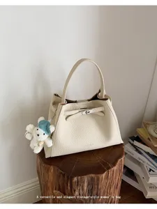 Detailed view of the elegant beige vintage handbag featuring a classic lock design and charm.