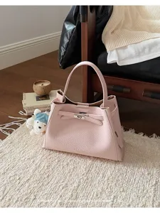 Detailed view of the pink leather handbag featuring elegant turn lock and textured finish.