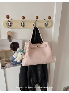 Stylish pink PU leather handbag with elegant strap lock and cute bear charm for women.