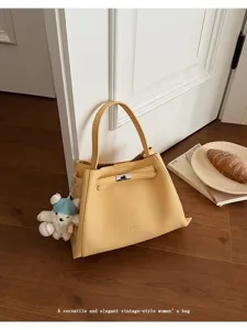 Classic yellow leather tote bag with elegant turn-lock closure and vintage style design.