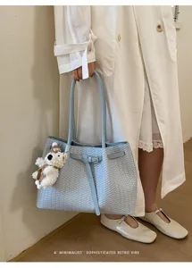 Light blue woven tote bag with bear pendant, stylish shoulder bag for daily commuting and summer.