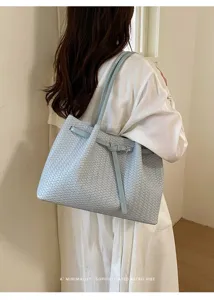 Light blue woven leather tote bag for women, stylish minimalist shoulder bag with buckle detail.