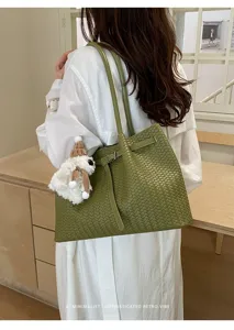 Green woven leather tote bag, elegant shoulder handbag with cute bear pendant, stylish daily style.