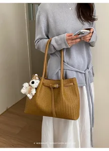 Brown woven leather tote bag for women, stylish vintage shoulder bag with plush charm.