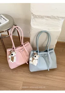 Detailed view of stylish woven tote bag with cute bear pendant, premium texture and chic design.
