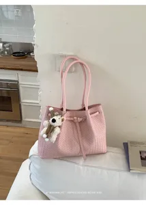 Pink woven tote bag for women, stylish bucket handbag with double handles and cute bear pendant.