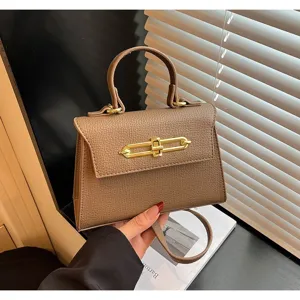 Braune strukturierte Henkeltasche Detail, elegante Lederhandtasche mit goldenem Metallverschluss.
