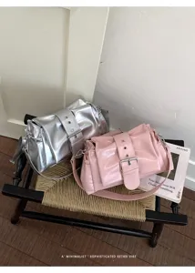 Detailansicht trendiger metallischer und rosa Knitteroptik Schultertaschen mit großer Schnalle.