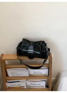 Modische schwarze Lackleder-Achsel-Umhängetasche mit Schnalle im minimalistischen Retro-Stil.