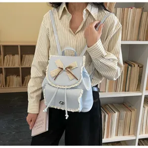 Detailed view of light blue backpack with lace and bow on a model