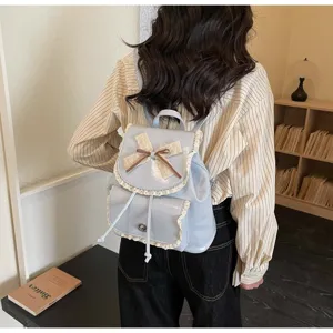 A model wearing a stylish light blue backpack with elegant lace trim and bow knot