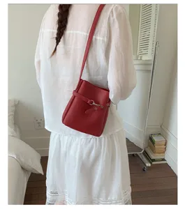 Sac seau élégant en cuir PU rouge pour femme, sac bandoulière chic avec boucle métallique.