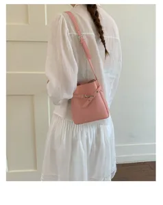 Vue détaillée d'un sac sceau en cuir rose élégant porté avec une bandoulière.