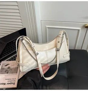 Vista dettagliata della borsa a spalla hobo bianca elegante con catena in metallo e fibbie.