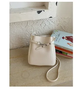 Vue détaillée du sac seau bandoulière blanc minimaliste avec fine sangle et belle finition.