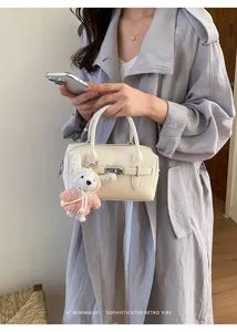 Detailansicht der eleganten Leder-Bowlingtasche mit süßem Strick-Hasenanhänger für den Alltag.