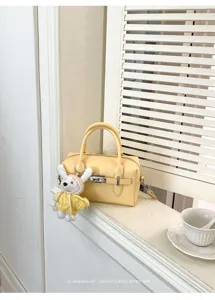 Detailaufnahme der stilvollen gelben Leder-Bowlingtasche mit Textur und Metallschloss.