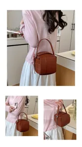 Braune Leder-Würfelhandtasche Detailansicht, stilvoller Kettenriemen und modernes Design.