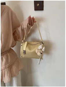 Modische gelbe Schultertasche für Damen mit süßem Plüschbären Anhänger und Metallverschluss.