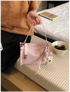 Rosa Umhängetasche für Damen, modische Handtasche mit Bärenanhänger und Schlossdetail.