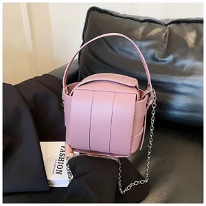 Rosa trendy Eimerhandtasche Detail zeigt PU Leder Struktur und Metallkettenriemen.