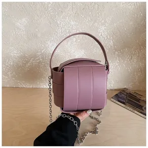 Nahaufnahme der trendigen lila Lederhandtasche mit gewebter Struktur und Metallkette.