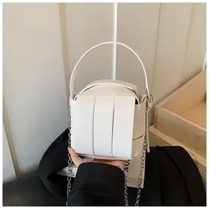 Weißes Handtaschen-Design aus Leder mit vertikalen Paneelen, Henkel und schickem Kettengurt.