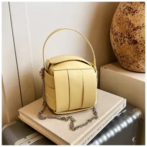 Detailansicht der gelben quadratischen Umhängetasche mit schicker Kette und Handgriff.
