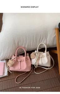 Schickes gewebtes Handtaschen-Detail mit süßem Bärenanhänger für modebewusste Frauen.