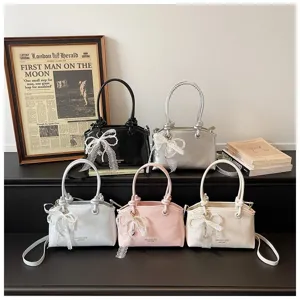 Detailansicht von modischen Damenhandtaschen mit Spitzen-Perlen-Schleifen in bunten Farben.
