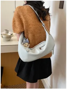 Detailansicht der hellblauen Hobo-Umhängetasche am Model, lässiges Accessoire für den Alltag.