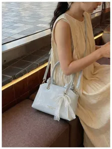 Elegante hellblaue Damentasche mit Spitzenperlenanhänger, stilvolle Umhängetasche Detailansicht.