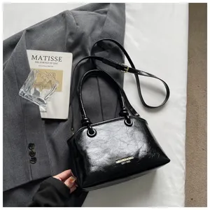 Detailansicht der schwarzen Lackleder Handtasche mit sehr eleganten Metallbeschlägen.