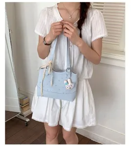 Detail view of the light blue shoulder tote bag featuring cute bunny pendant and lace ribbon.