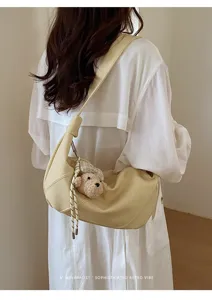 Schicke hellgelbe Achseltasche mit Bärenanhänger, stilvolles Retro-Design für Damen.