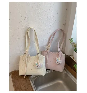 Detailed view of casual large capacity floral print tote shoulder bag with cute bunny plush charm.