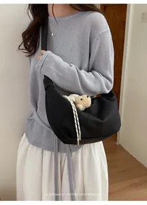 Stilvolle schwarze Halbmond-Umhängetasche mit Bärenanhänger, minimalistische Achseltasche.