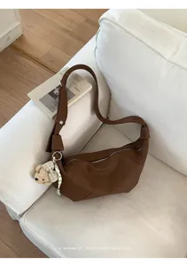 Braune Kunstleder Hobo Schultertasche Detailansicht mit Bärenanhänger und Reißverschluss.
