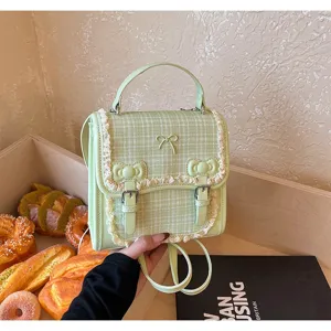 Detailed shot of a cute green plaid mini backpack with delicate lace trim and lovely bows.