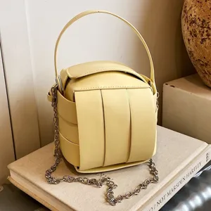 Chicke gelbe strukturierte Handtasche mit Henkel und stilvollem Kettengurt für Damen im Sommer.