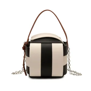 Schicke schwarz-weiße Würfel-Handtasche für Damen mit braunem Griff und stilvollen Metallketten.