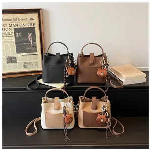 Sac seau chic en cuir PU avec charmant pendentif d'ours et design bandoulière élégant.