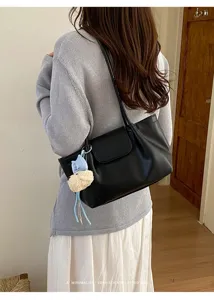 Elegante bolso de hombro negro casual para mujer con un lindo colgante de peluche.