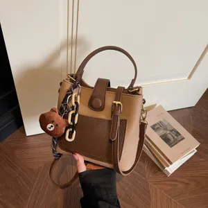 Sac seau bicolore pour femme, sac bandoulière élégant avec charm ours mignon et chaîne.