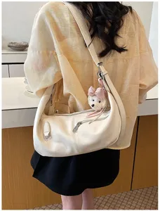Detailansicht der cremefarbenen Beuteltasche mit süßem Bärenanhänger aus weichem Leder.